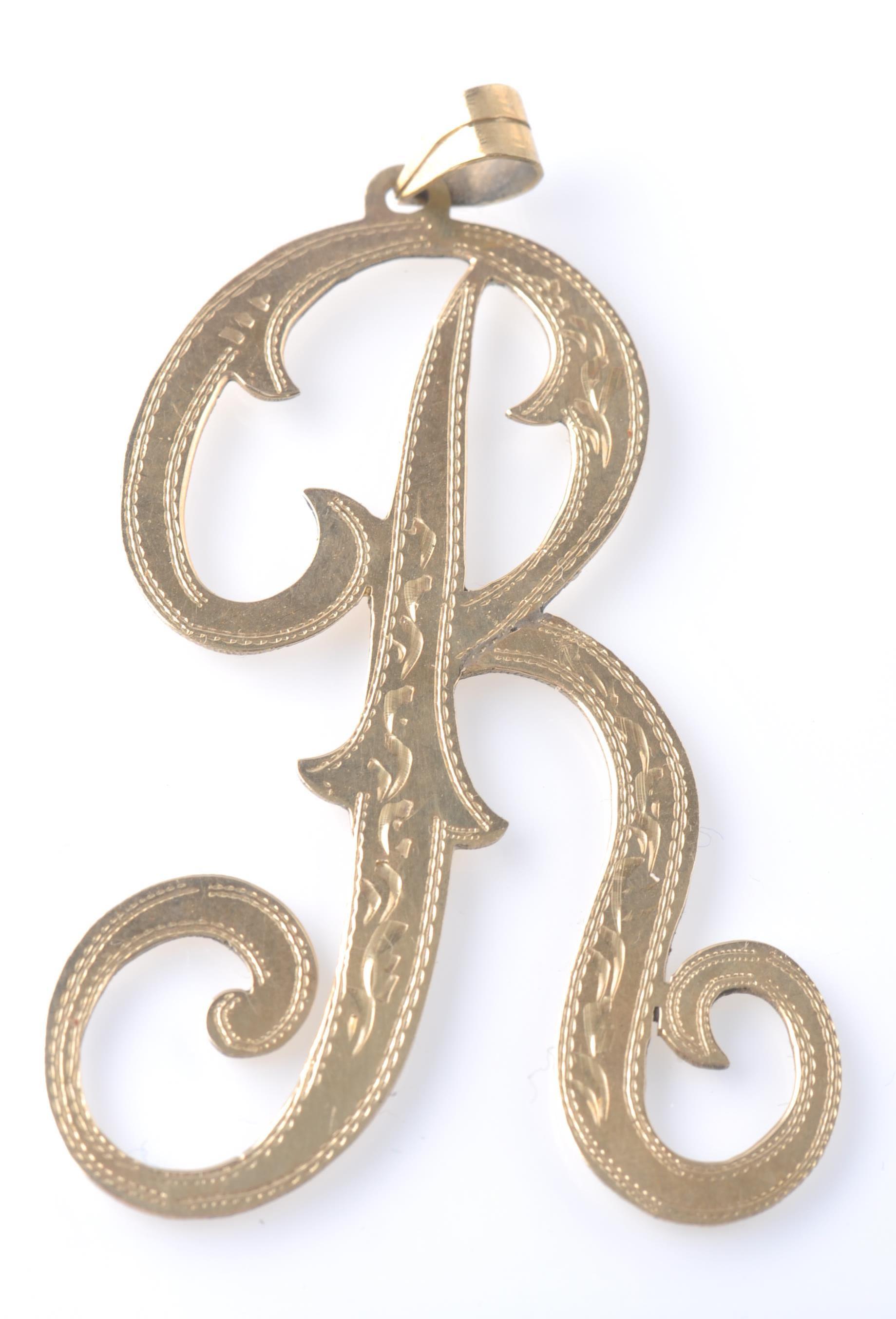 AN OVERSIZED 14CT GOLD PENDANT IN THE FORM OF THE LETTER R