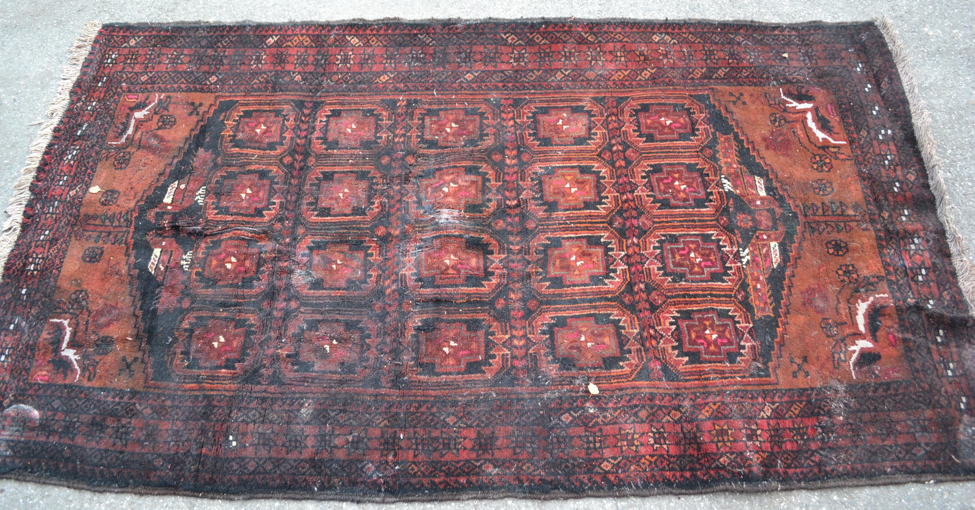 A 20th century dark red and blue ground Persian / Islamic Bokhara rug having a central panel of