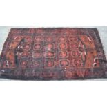 A 20th century dark red and blue ground Persian / Islamic Bokhara rug having a central panel of