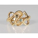 A stamped 9ct gold ladies dress ring having a crossover knot design set with two round cut blue