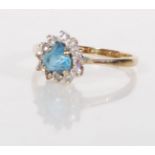 A hallmarked 9ct gold ladies ring set with a heart cut blue stone with a halo of white stones.