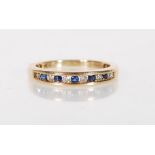 A stamped 9ct gold ring being channel set with alternate blue and white stones. Weight 2.3g. Size