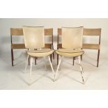 A set of four industrial dining chairs having metal tubular framed with shaped wooden back rests and