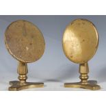 A pair of 19th Century brass tilt top candle stands / reflectors having round tops raised on faceted