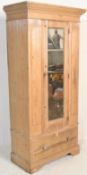 An early 20th Century scrubbed pine single wardrobe, single mirrored panel door over deep drawer,