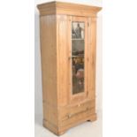 An early 20th Century scrubbed pine single wardrobe, single mirrored panel door over deep drawer,