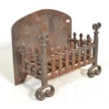 A late 19th Century Victorian cast iron fire grate with decorative fleur-de-lys detailing and scroll