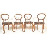 A set of four 19th Century Victorian walnut balloon back dining chairs raised on cabriole legs,