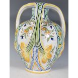A late 19th Century Italian faience tri handled vase decorated with floral sprays having yellow