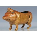 An early 20th Century cast brass pin cushion in the form of a pig, having a space for a cushion to