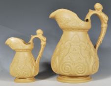 A pair of 19th Century graduating slip-ware jugs of tapering bulbous form having raised foliate
