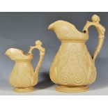 A pair of 19th Century graduating slip-ware jugs of tapering bulbous form having raised foliate