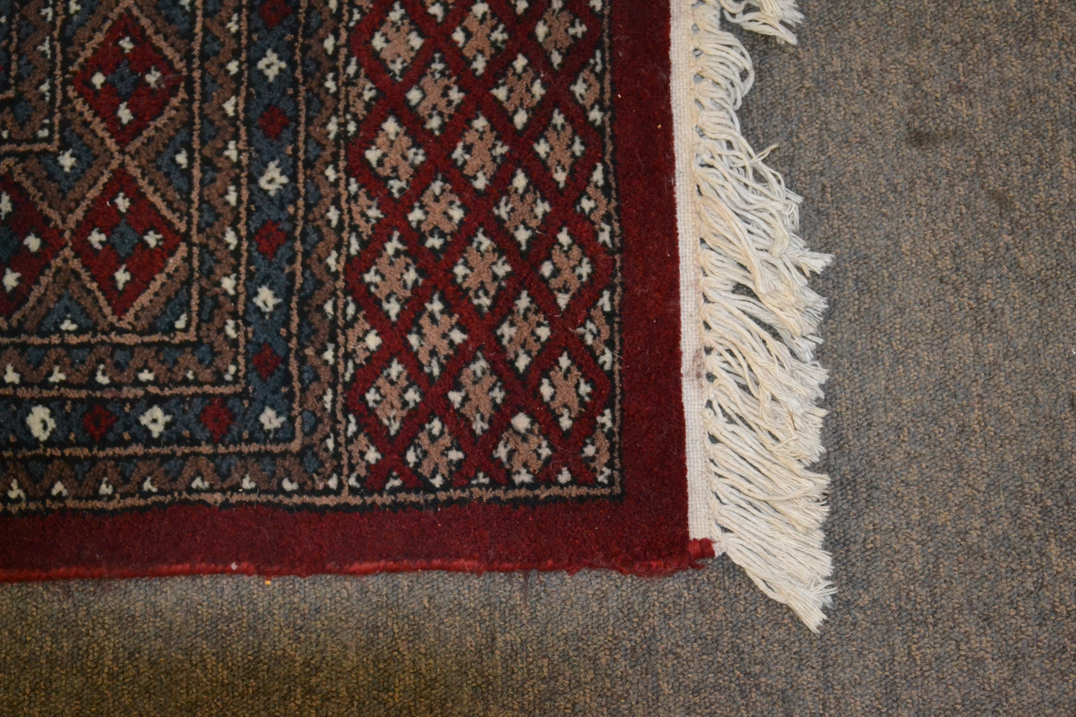 A 20th Century hand knotted floor rug carpet of large proportions in a Bukhara design having a red - Image 5 of 6