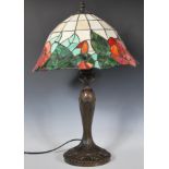 A 20th Century Tiffany style table lamp having a cast bronze effect lamp base of tapering of
