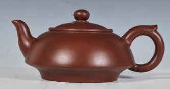 A 20th Century Chinese ceramic brown clay teapot of small proportions having character marks to