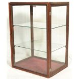 A early 20th Century oak counter-top display cabinet of simple rectangular form with curved shaped