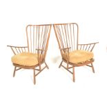 Ercol - A 20th century Windsor pattern pair of armchairs in beech and elm golden dawn having shaped