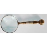 A 20th Century brass hand held magnifying glass with mother of pearl in lay to handle. Measures 25cm