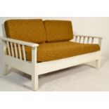 A vintage retro 20th Century wooden framed sofa having slatted backrest and arm supports with 1970's