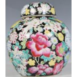 A 20th Century Chinese ginger jar of bulbous form having hand painted floral sprays on a black