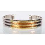 A stamped 950 open cuff silver bangle bracelet having a reeded design with hammered decoration and a
