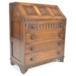 A 20th Century Jaycee / Old Charm  style oak bureau desk with linen fold decoration to the fall