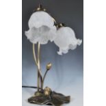 An Art Nouveau style table lamp having a naturalistic lily pad base with stems of scroll form and