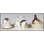 A group of three Crown Derby paperweights with two having gold stoppers and one silver to include