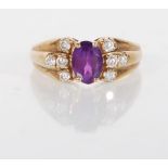 A hallmarked 9ct yellow gold ladies dress ring prong set with a central oval faceted cut purple