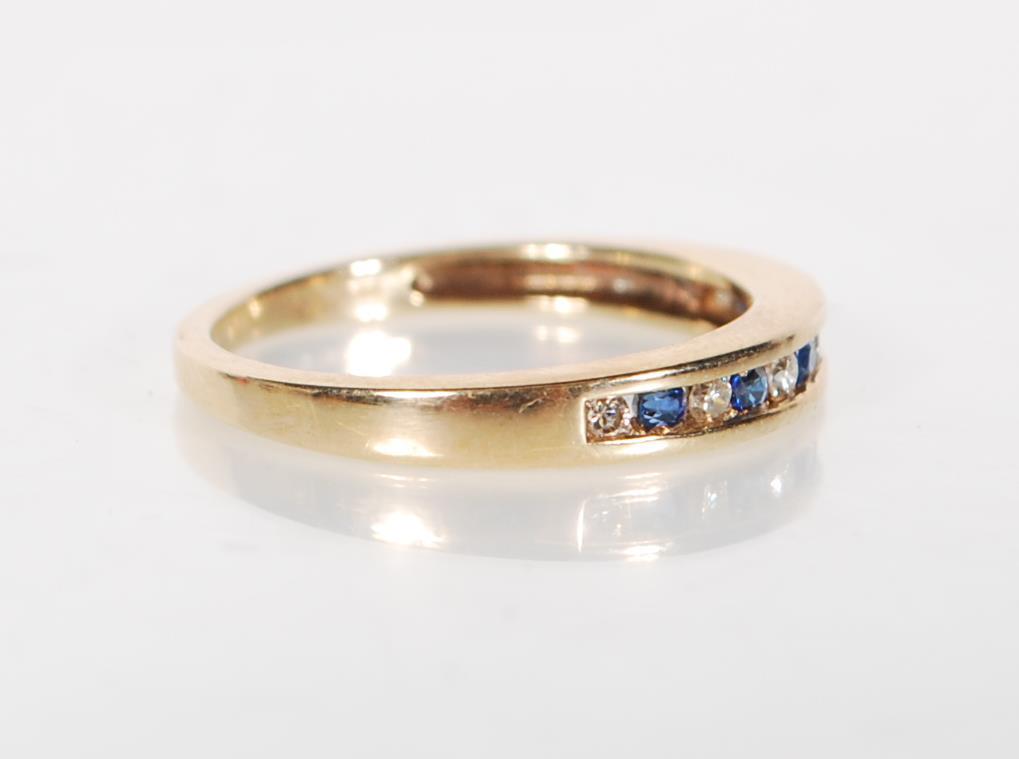 A stamped 9ct gold ring being channel set with alternate blue and white stones. Weight 2.3g. Size - Image 2 of 6