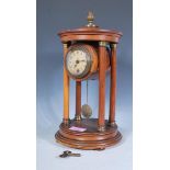 An early 20th Century mahogany pendulum portico mantel clock raised on a round plinth base, the