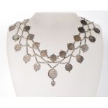 A 20th century Indian silver white metal coin collar necklace having two rows of round embossed