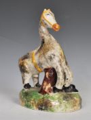 An early 19th Century Staffordshire ceramic figure of a horse and farrier with his dog, raised on