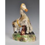 An early 19th Century Staffordshire ceramic figure of a horse and farrier with his dog, raised on