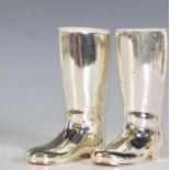 A pair of silver plated drinks measures in the form of rising boots, one measuring a full and the