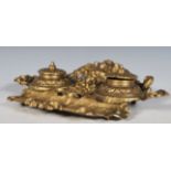 A 20th Century cast brass desk tidy / inkstand, with dual inkwells having embossed covers. To the