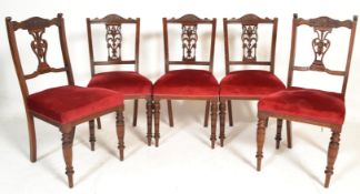 A set of 4 late Victorian mahogany dining chairs raised on turned legs with red velour overstuffed