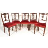 A set of 4 late Victorian mahogany dining chairs raised on turned legs with red velour overstuffed