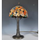 A 20th Century Tiffany style table lamp having a bronze effect base with a textured column having