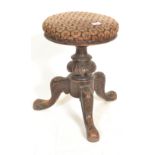 A 19th Century mahogany piano / music stool having a round upholstered cushion set raised on a