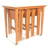 A vintage mid 20th Century teak side - nest of tables with four slide out metamorphic round teak