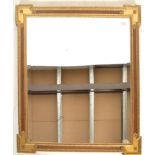 A 20th Century contemporary wall hanging mirror of canted rectangular form, gilt gesso moulded frame