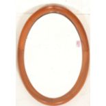 A retro mid 20th Century teak framed mirror of oval form having a thick curve design. 65cm x 38cm