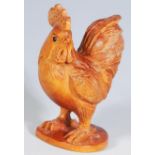 A finely carved boxwood netsuke in the from of a rooster set with glass eyes. Signed to base.