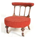 A 19th Century Victorian aesthetic mahogany nursing chair raised on turned legs with castors,