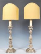 A pair of 20th Century white metal table / bedside lamps of rococo form having knopped columns