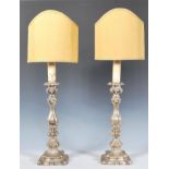 A pair of 20th Century white metal table / bedside lamps of rococo form having knopped columns