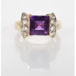 A hallmarked 9ct gold ladies dress ring set with a square cut purple stone flanked by eight round