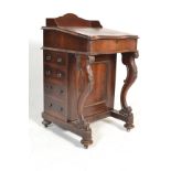 A Victorian 19th century rosewood davenport desk being raised on scroll supports with carved