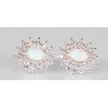 A pair of silver stud earrings set with central opal cabochons surrounded by CZ's. Stamped 925.